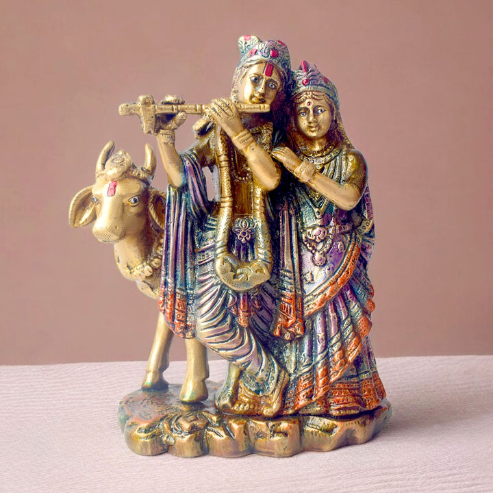 The 6.3 Inch Sacred Radha Krishna with Kamdhenu Cow Idol beautifully captures the divine union of Radha and Krishna, symbolizing love, harmony, and devotion. Crafted with intricate details, this idol features Radha and Krishna in an intimate and graceful pose, with Krishna playing his flute and Radha beside him, embodying the essence of their eternal bond.