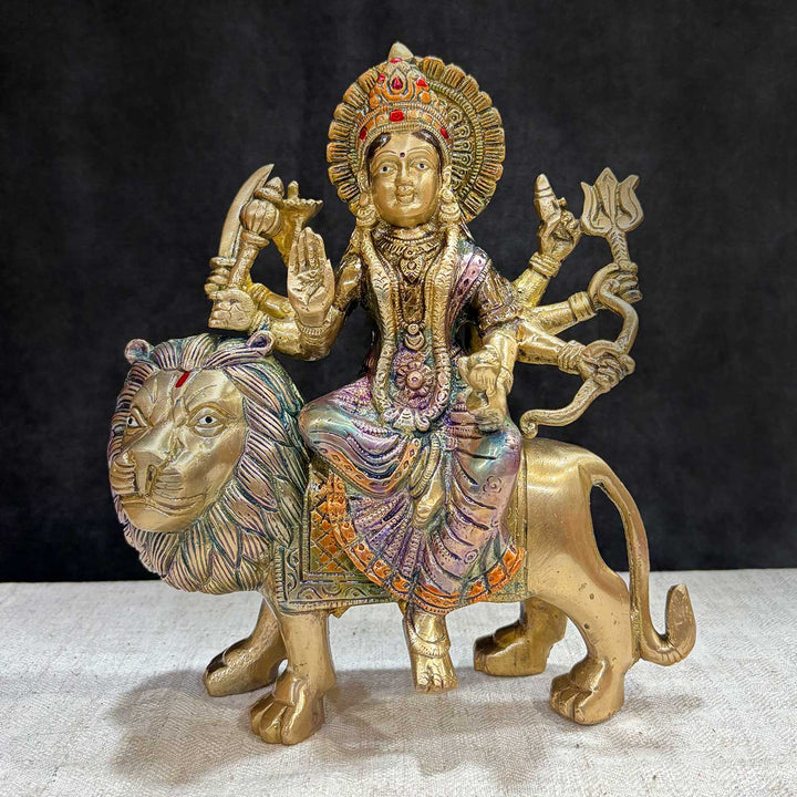 Embrace the powerful energy of Maa Durga with this 9-inch Brass 8-Armed Durga Idol, beautifully depicted riding her mighty lion. This meticulously crafted statue showcases Maa Durga in her most majestic form, symbolizing strength, courage, and divine protection.